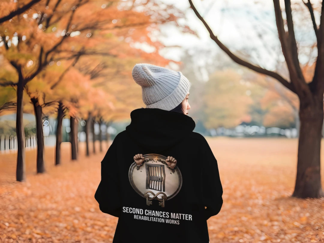 Second Chances Matter Rehabilitation Hoodie worn in autumn park; back shows circular emblem with a chair.