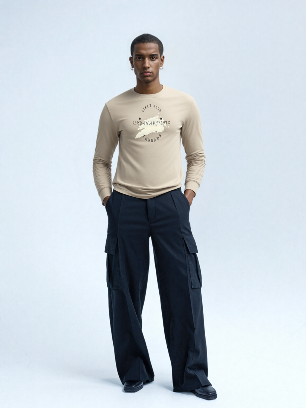 Male model in beige Urban Artistic Threads Signature Logo Long Sleeve tee with dark cargo pants.