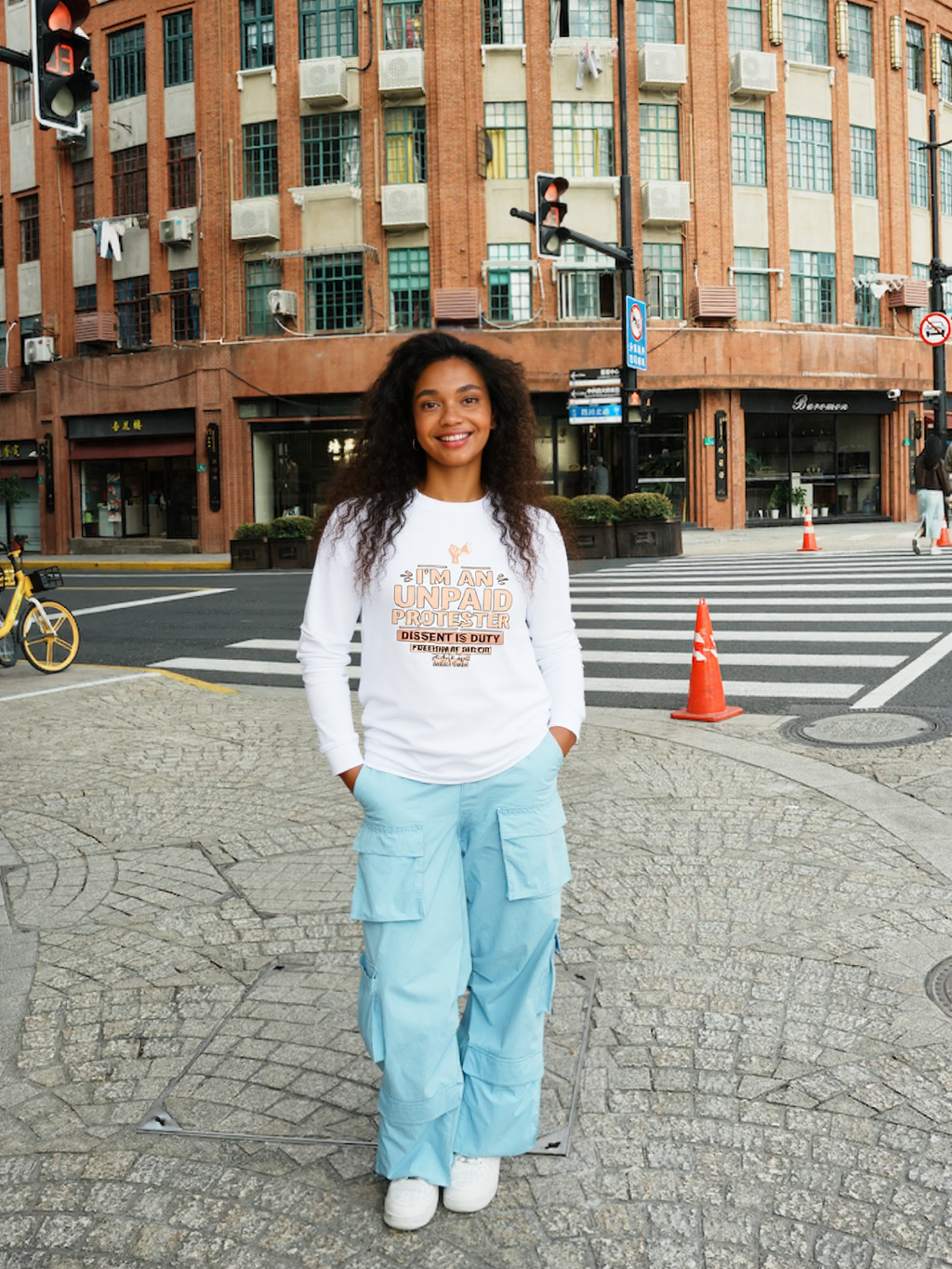 Urban Artistic Threads: I'M AN UNPAID PROTESTER Premium Long Sleeve Shirt worn by a woman with bold typography.