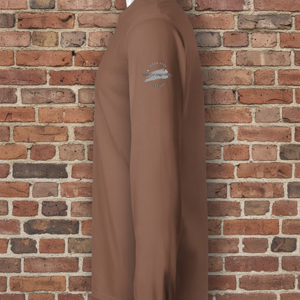 Brown long sleeve skate tee with small white circular logo on the upper sleeve against a brick wall.