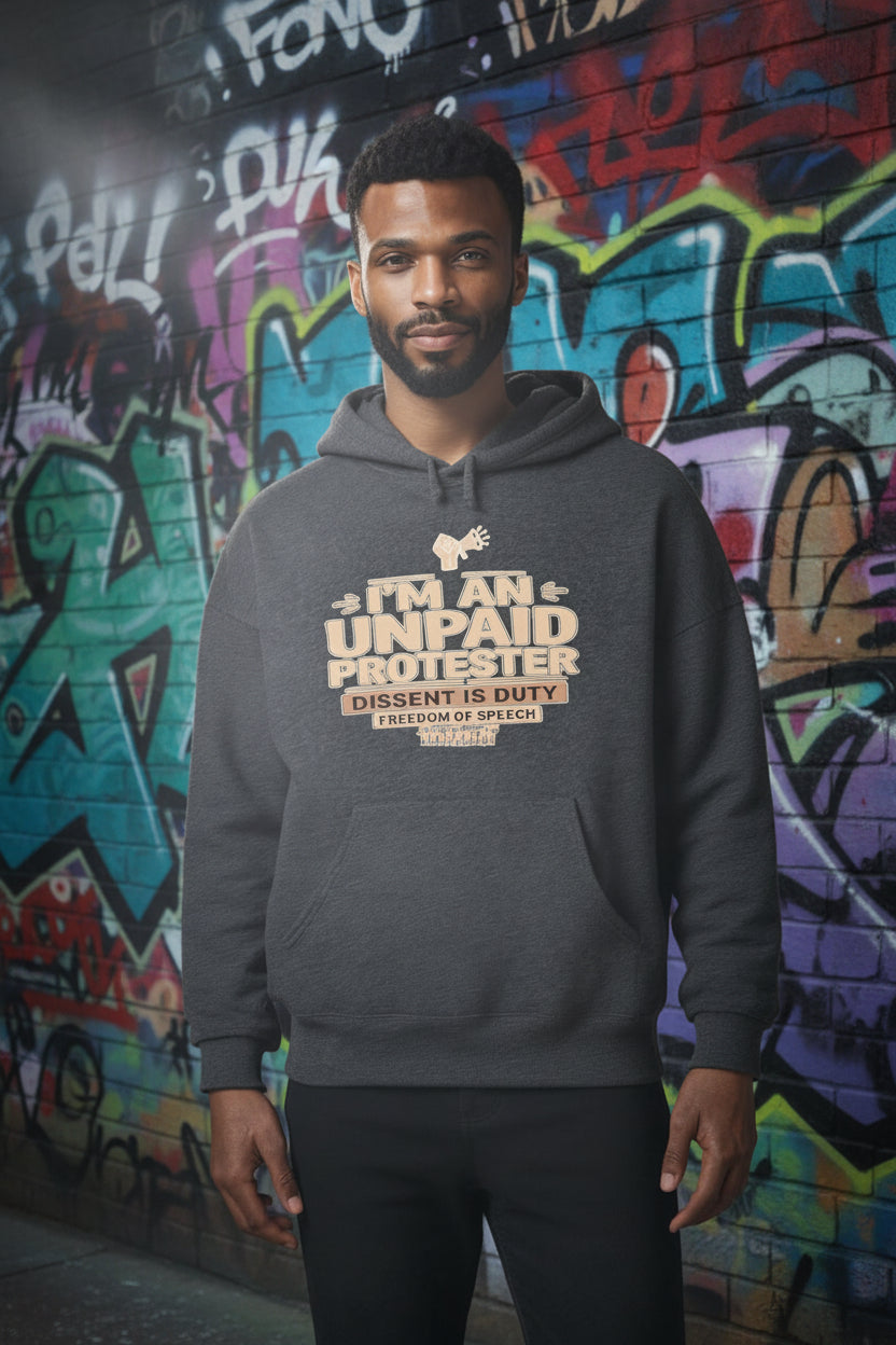 Man in gray Unpaid Protester Hoodie with Dissent Is Duty text, standing before colorful graffiti wall.